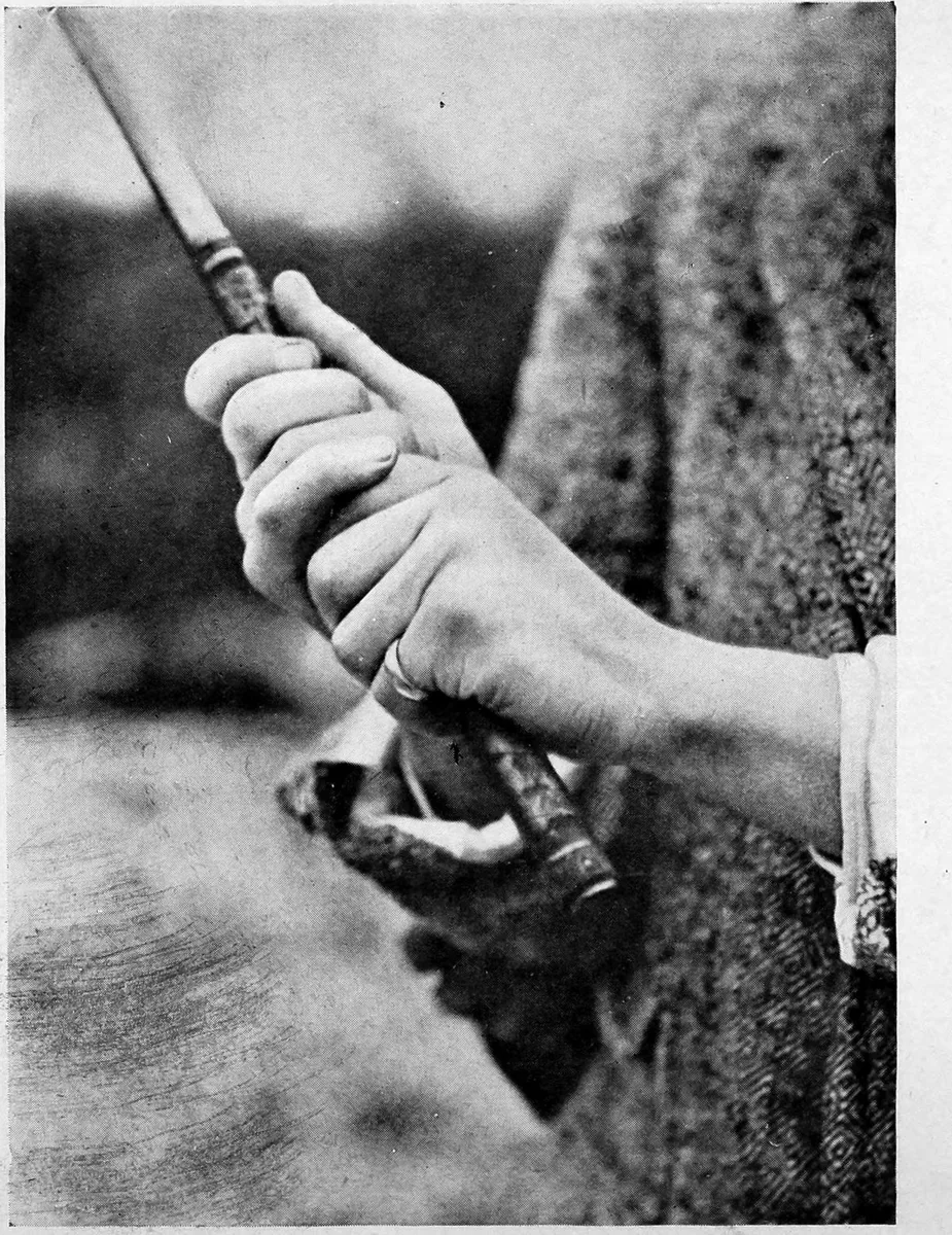 The overlapping grip from the side, showing the trail hand covering the lead thumb